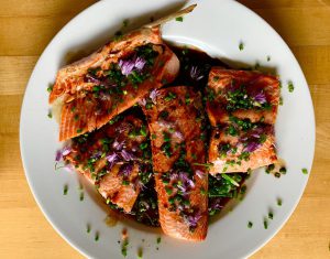 salmon on a plate sprinkled with purple flowers