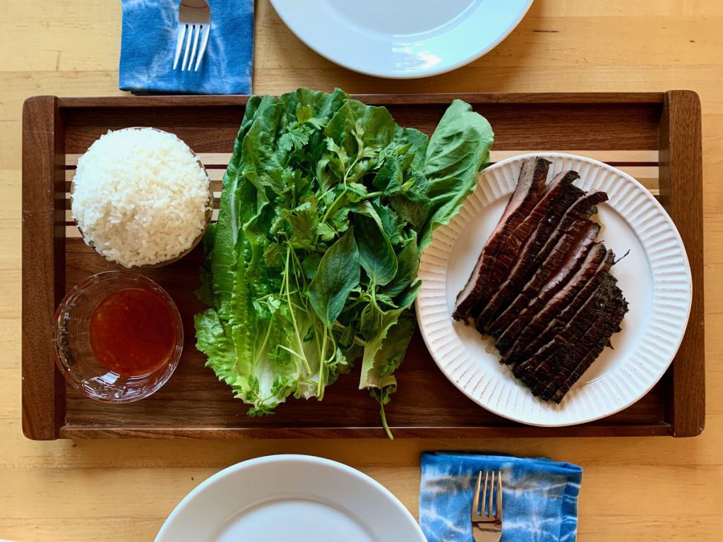 steak, lettuce, sauce and rice on a tray