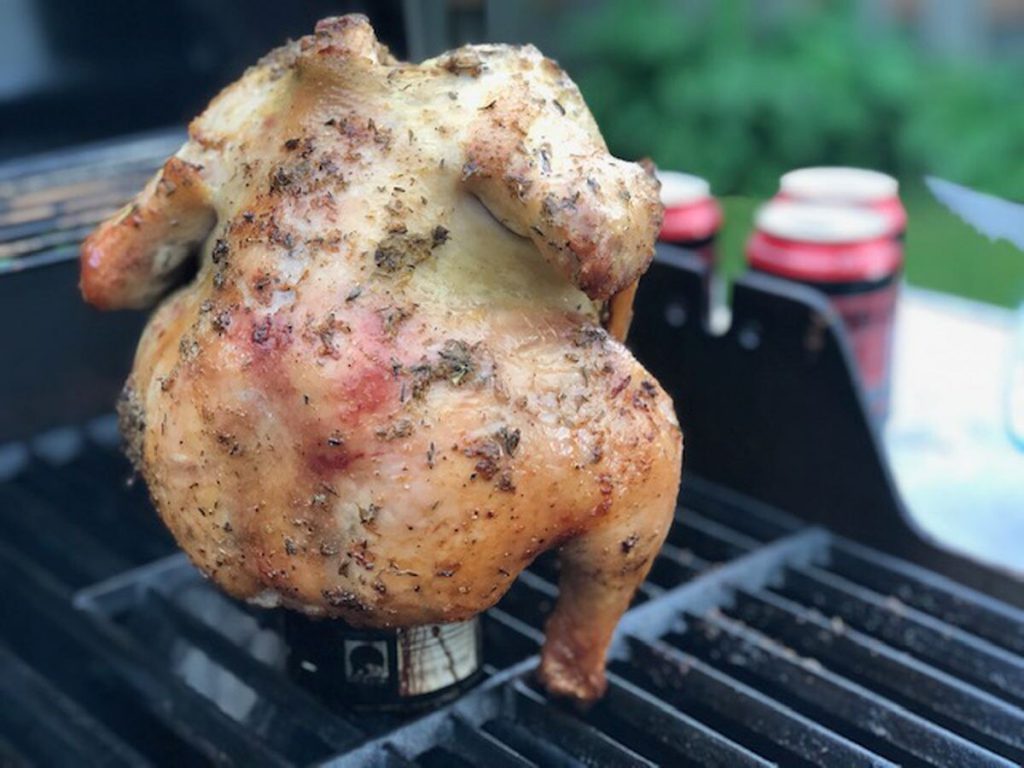 chicken standing up on a grill