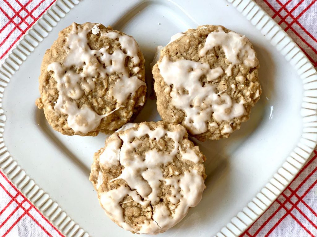 Three iced oatmeal cookies on a plate
