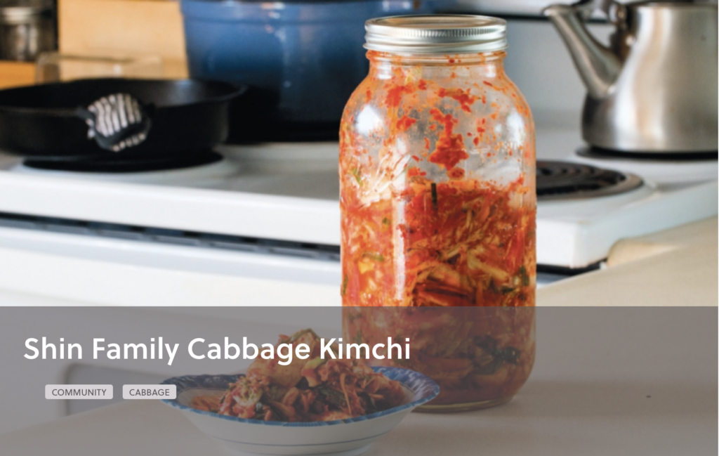 Jar of red-colored kimchi next to a small bowl of kimchi