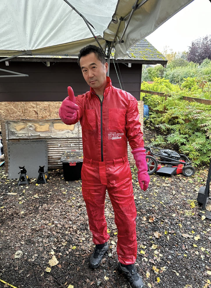 Man in a red jump suit and pink rubber gloves